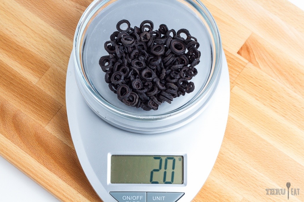 Dehydrated black olives look like lego wheels 20 grams dehydrated sliced black olives on a scale