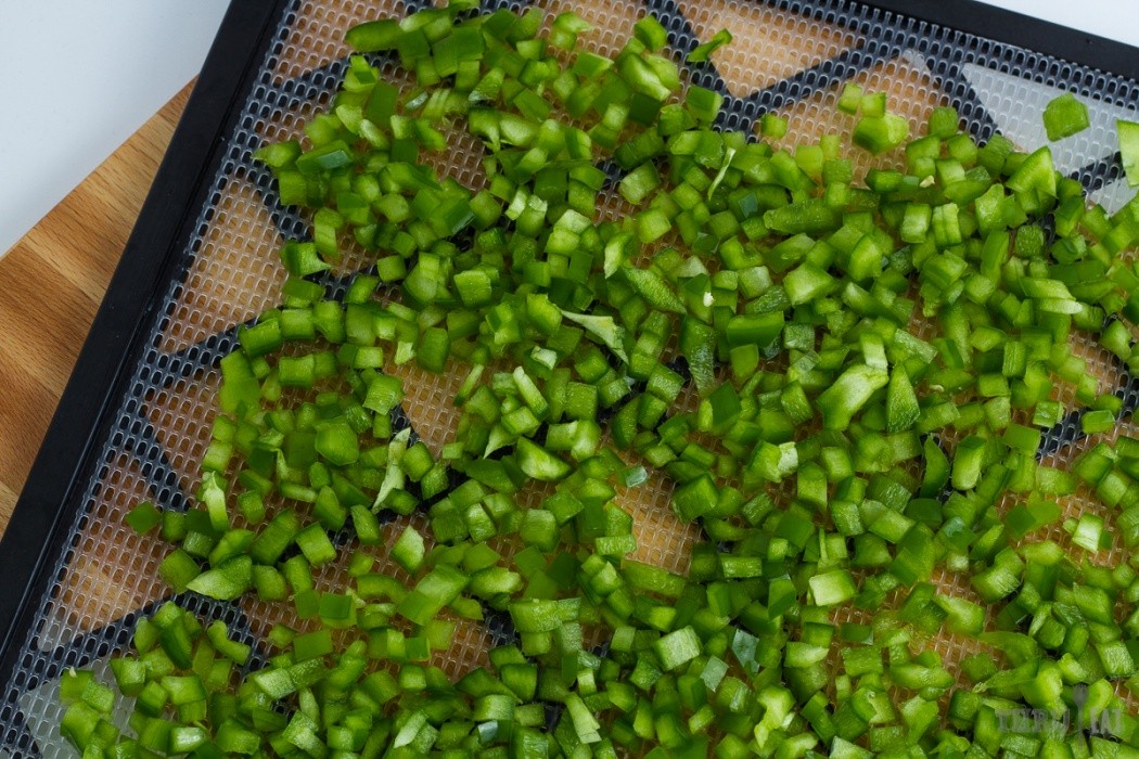 diced green bell pepper on a dehydrator tray