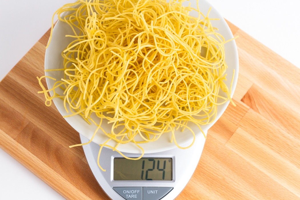 124 grams of dehydrated spaghetti noodles on a scale