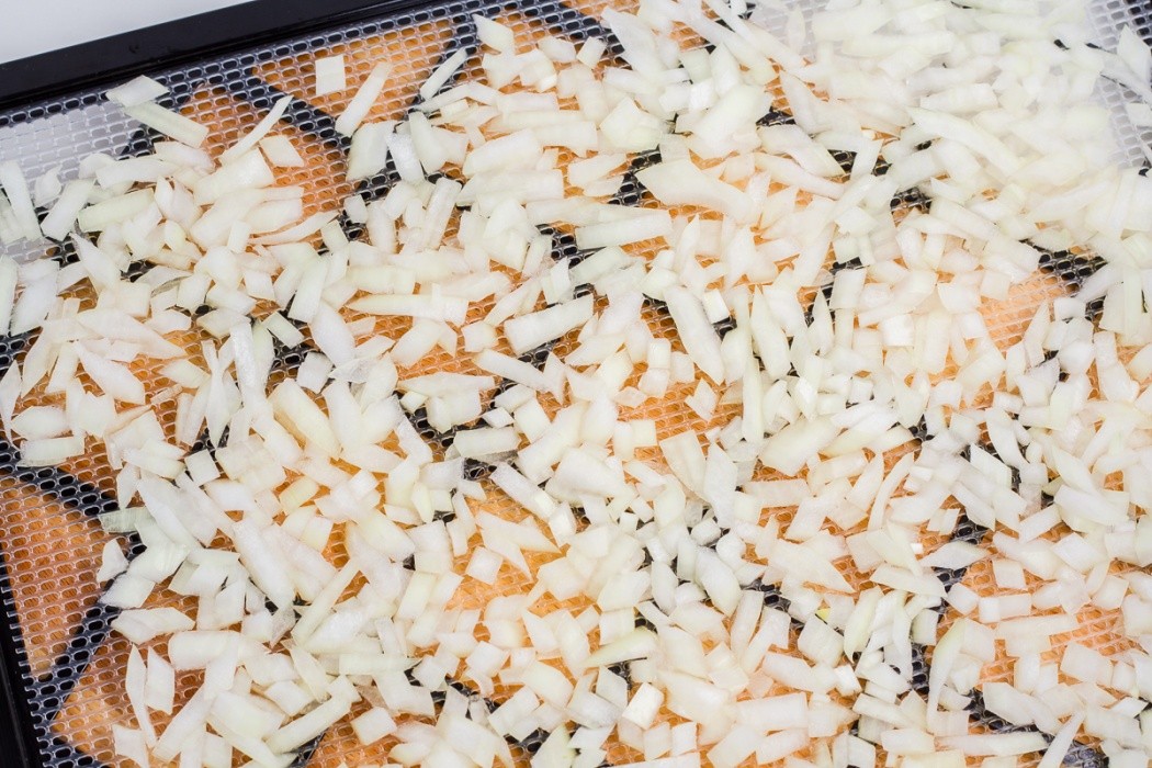 diced onions spread on a dehydrator tray