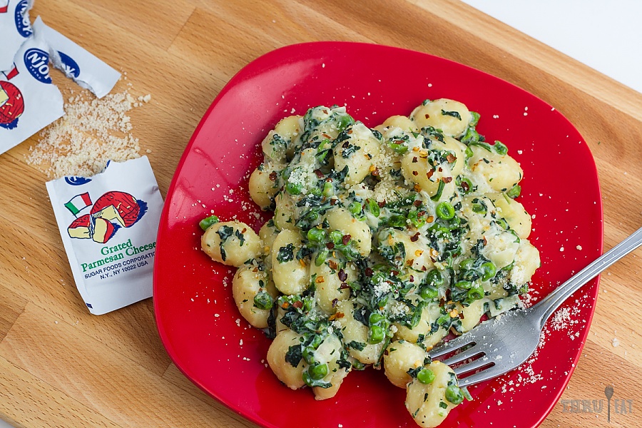 Lemon gnocchi looks fancy, but is incredibly easy and hearty for backpacking Lemon gnocchi with spinach and peas on a red plate