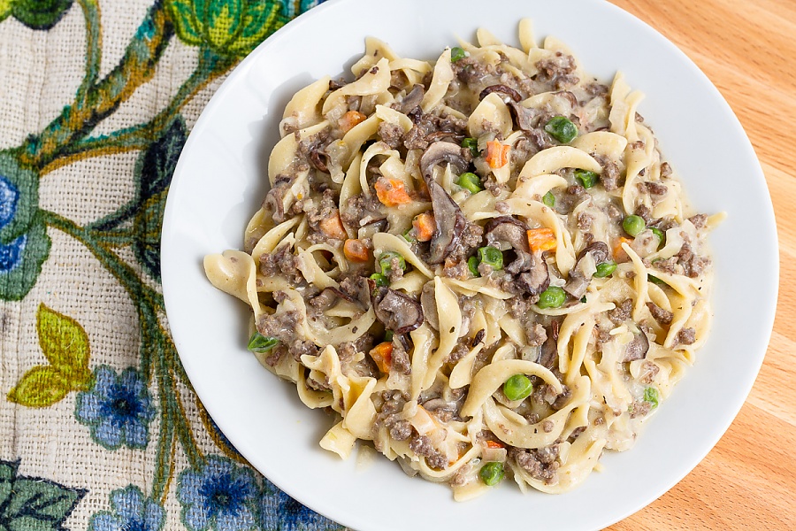 plated hamburger stroganoff with peas, carrots, and mushrooms