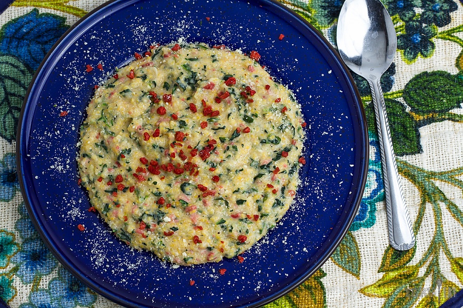 Parmesan spinach and bacon grits on a blue plate