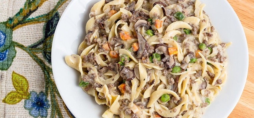 plated hamburger stroganoff with peas, carrots, and mushrooms