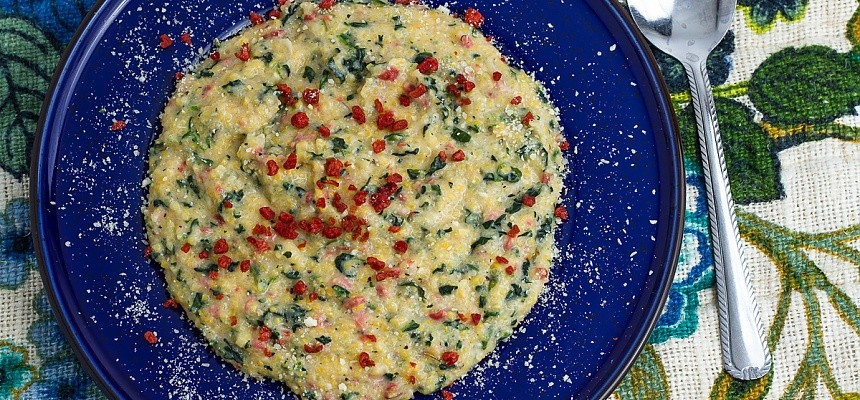 Parmesan spinach and bacon grits on a blue plate