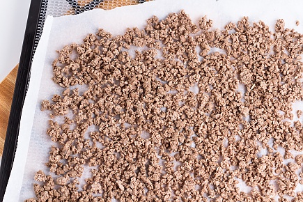 ground beef laid out on dehydrator tray